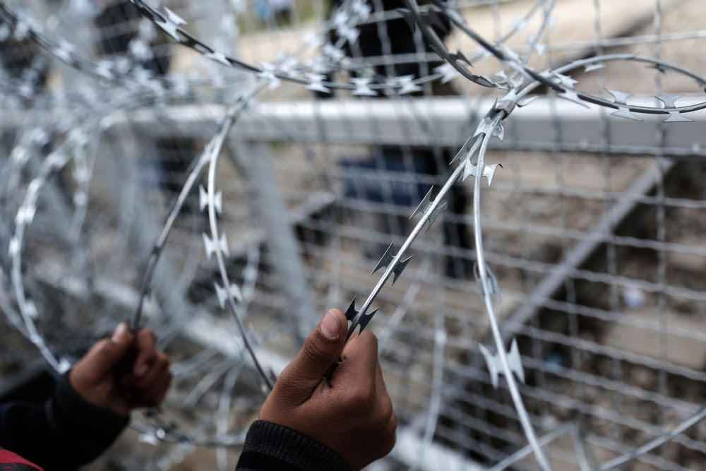 An Afghan child holds the fence during protest at the Greek-Macedonian (FYROM) border near the northern Greek village of Idomeni.
