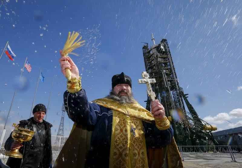 An Orthodox priest conducts a blessing in front of the Soyuz TMA-20M for the next International Space Station (ISS) crew, comprised of Jeff Williams of the U.S. and Oleg Skriprochka and Alexey Ovchinin of Russia, at the launchpad at the Baikonur cosmodrome, Kazakhstan, March 17, 2016, ahead of its launch scheduled on March 19. (REUTERS/Shamil Zhumatov)