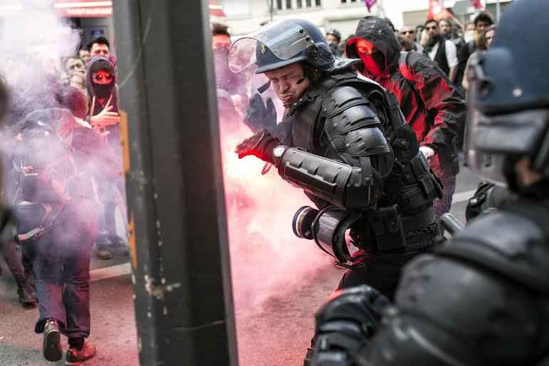 A policeman reacts during a clash with protestors during a protest against the proposed changes to France's working week and layoff practices, in Lyon, central France, Thursday, April 28, 2016. French protesters are back on the streets over proposed reforms to the country's labor rules and strikers have forced cancellations and delays at two airports serving Paris. (AP Photo/Laurent Cipriani) CIP104 (Laurent Cipriani / The Associated Press)