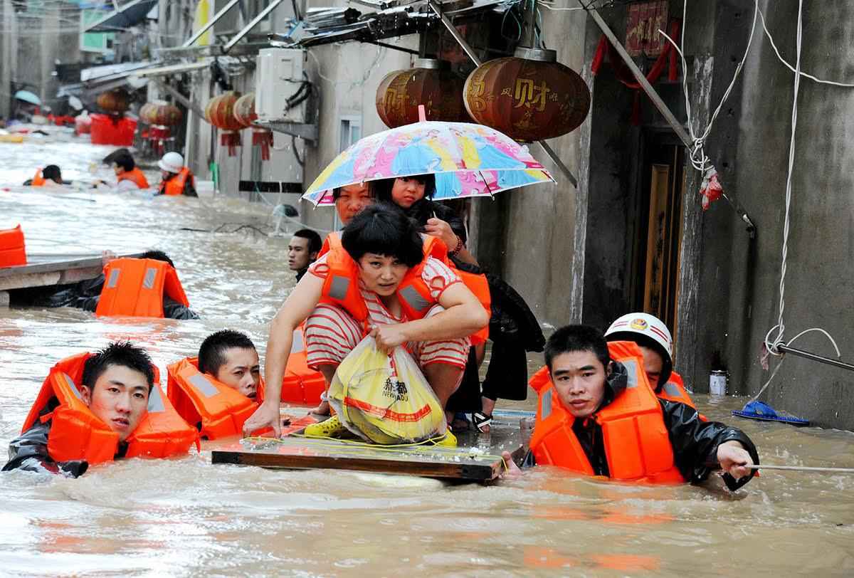 TOPSHOT - Rescuers evacuate residents through floodwaters brought by typhoon Megi in Ningde, eastern China's Fujian province on September 28, 2016. Typhoon Megi smashed into the Chinese mainland on September 28 morning, killing one person, after leaving a trail of destruction and four people dead in Taiwan. / AFP / STR / China OUT        (Photo credit should read STR/AFP/Getty Images)