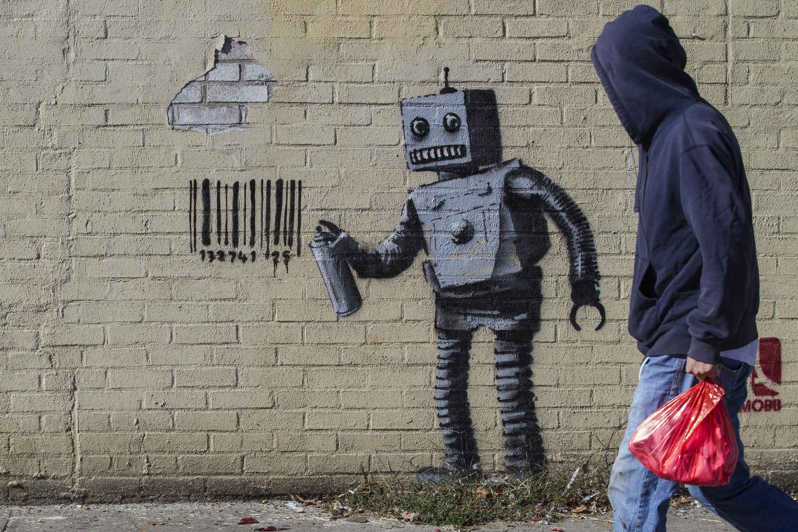 The newest art installation by British artist Banksy, a robot and a barcode, is seen on a wall in the Coney Island area of New York City, October 28, 2013. Famously jaded New Yorkers are getting swept up in the hype over Banksy, the renegade graffiti artist who is leaving his mark across the city this month.   REUTERS/Brendan McDermid (UNITED STATES - Tags: SOCIETY) - RTX14RU3